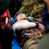 Personne blessée sur civière en forêt.